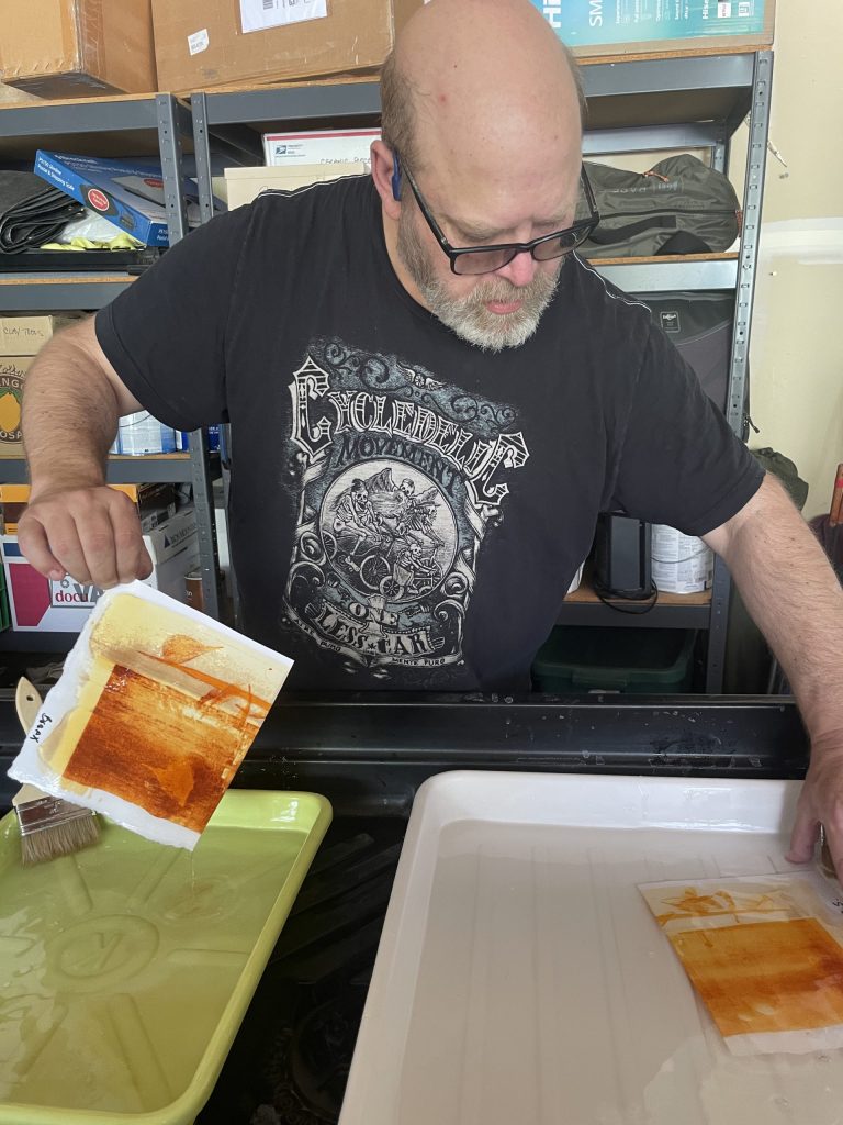 Here I'm processing the test prints in baths of borax and baking soda to see which one produced the most desirable outcome. We decided the Borax solution gave browner, amber tones, while the Baking Soda gave a much redder tone.
